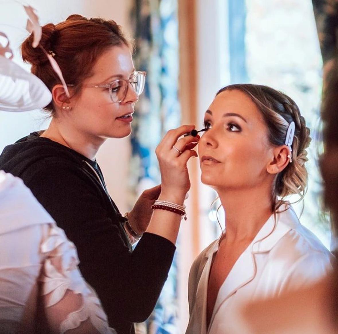 Dannielle applying bridal makeup to a bride at her wedding morning